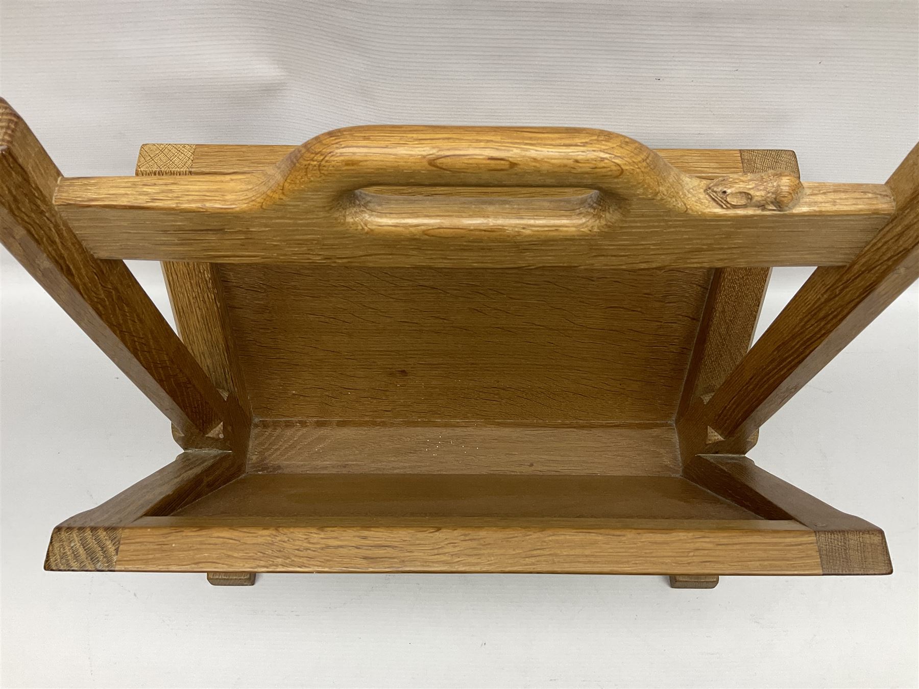 Mouseman - oak magazine rack, the top rail pierced with handle and carved with mouse signature, octagonal supports with two panelled and splayed sides, on sledge feet, by the workshop of Robert Thompson, Kilburn 