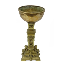  19th century cast and gilt brass oil lamp base, square column pierced with ribbon tied floral wreath, the tapering base with cherubs heads, impressed 'M747', with copper bowl on shaped bracket feet, H40cm   