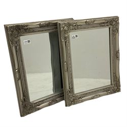 Pair bevelled edge wall mirrors in swept silvered frames decorated with ornate cartouches 
