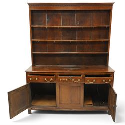 18th century oak dresser with rack, the three-tier plate rack with dentil-carved cornice, the plate shelves with moulded edge and wrought metal hooks, the base fitted with three drawers with brass swan-neck handles over three panelled cupboards, lower moulded edge on stile supports