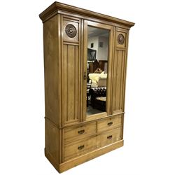 Edwardian light oak double wardrobe, single mirrored door flanked by rosette carved panels, above two short and one long drawer, on skirted base, with all over reeded and moulded decoration