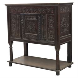 19th century oak cupboard cabinet, the moulded rectangular top above a deeply carved front carved with frieze of lunettes above a central panelled cupboard door with lozenge and foliate carving, flanked by vertical carved panels, upon turned legs with boarded lower shelf