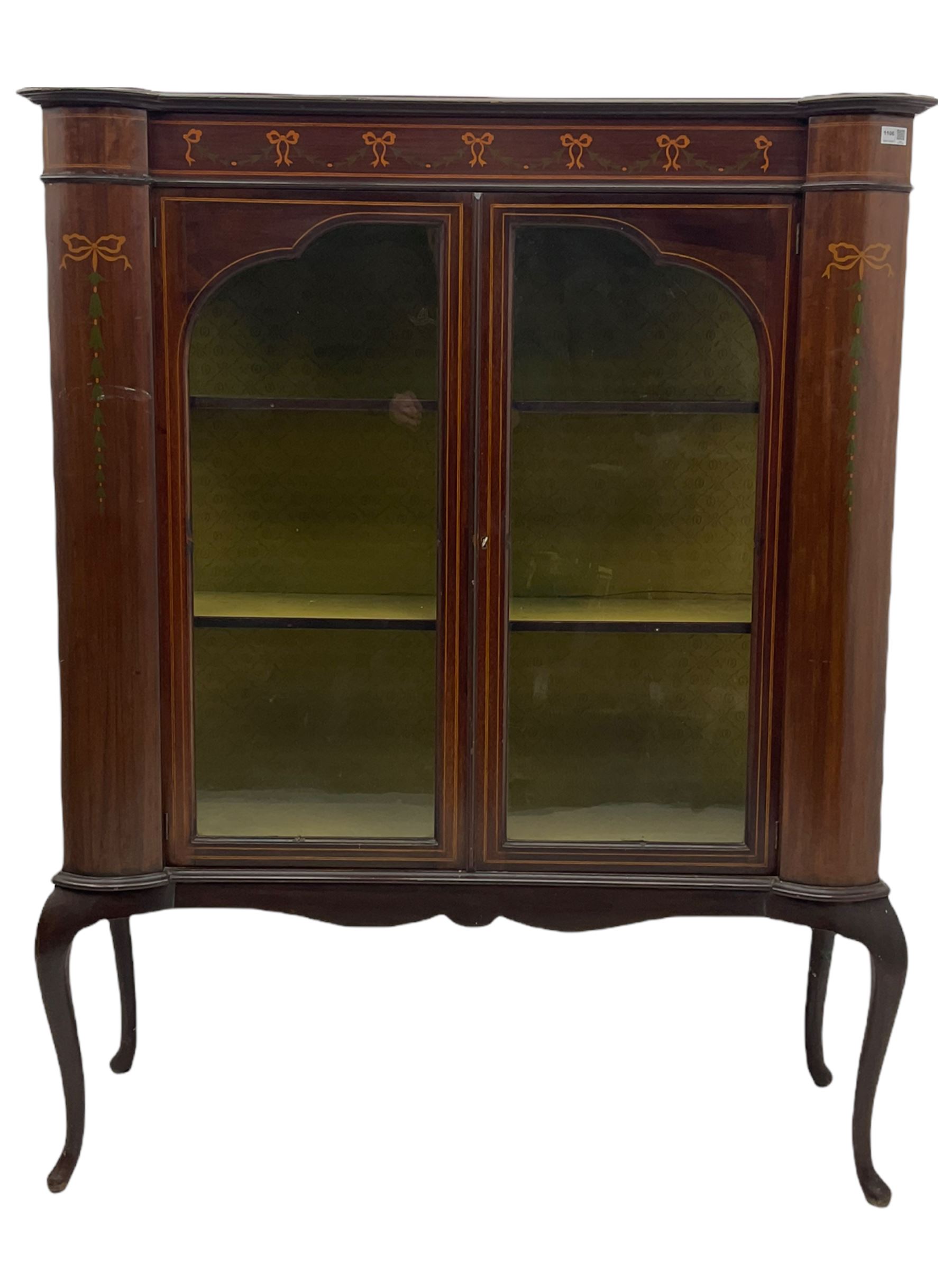 Edwardian mahogany display cabinet, shaped front with painted ribbon and bellflower garland decoration, enclosed by two glazed doors, cabriole supports