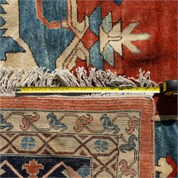 Exceptionally large Northwestern Persian Heriz, hand-knotted carpet, madder red field with a bold stepped medallion in indigo and ivory, and light blue spandrels within a dark indigo border of rosettes and angular vine motifs 




