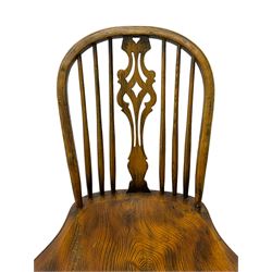 Set of four elm Windsor dining chairs, high hoop and stick back with shaped pierced splat, over shaped saddle seat, raised on ring turned supports joined by crinoline stretcher