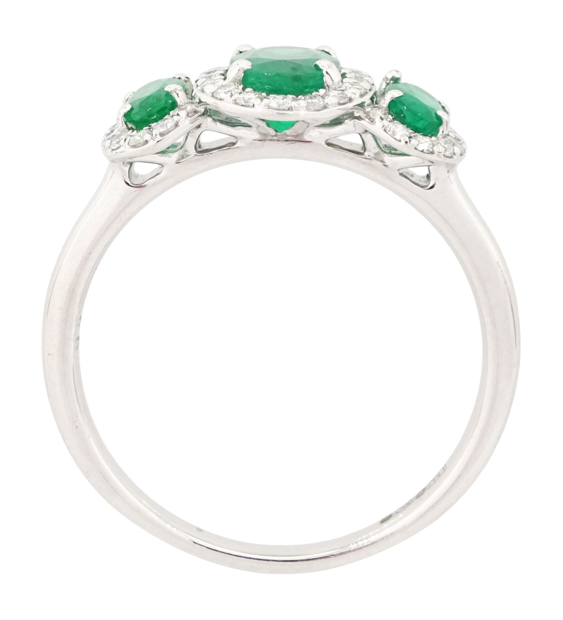 Platinum emerald and diamond trilogy ring, three oval cut emeralds surrounded by round brilliant cut diamonds, hallmarked, total emerald weight approx 1.05 carat, total diamond weight approx 0.25 carat