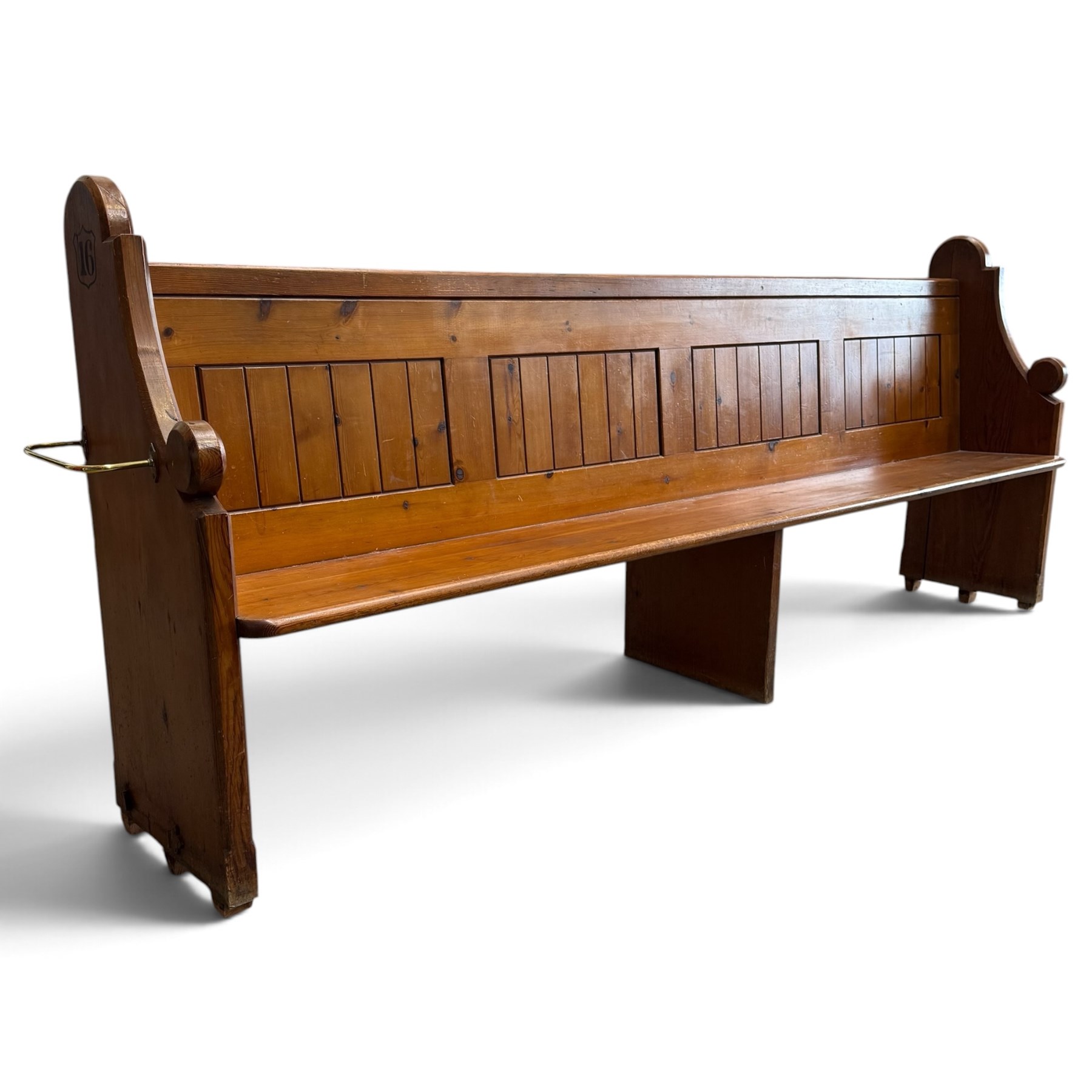 Early 20th century stained pine ecclesiastical church pew, the shaped end supports flanking slatted and panelled back, with black stencilled number '16' to the side