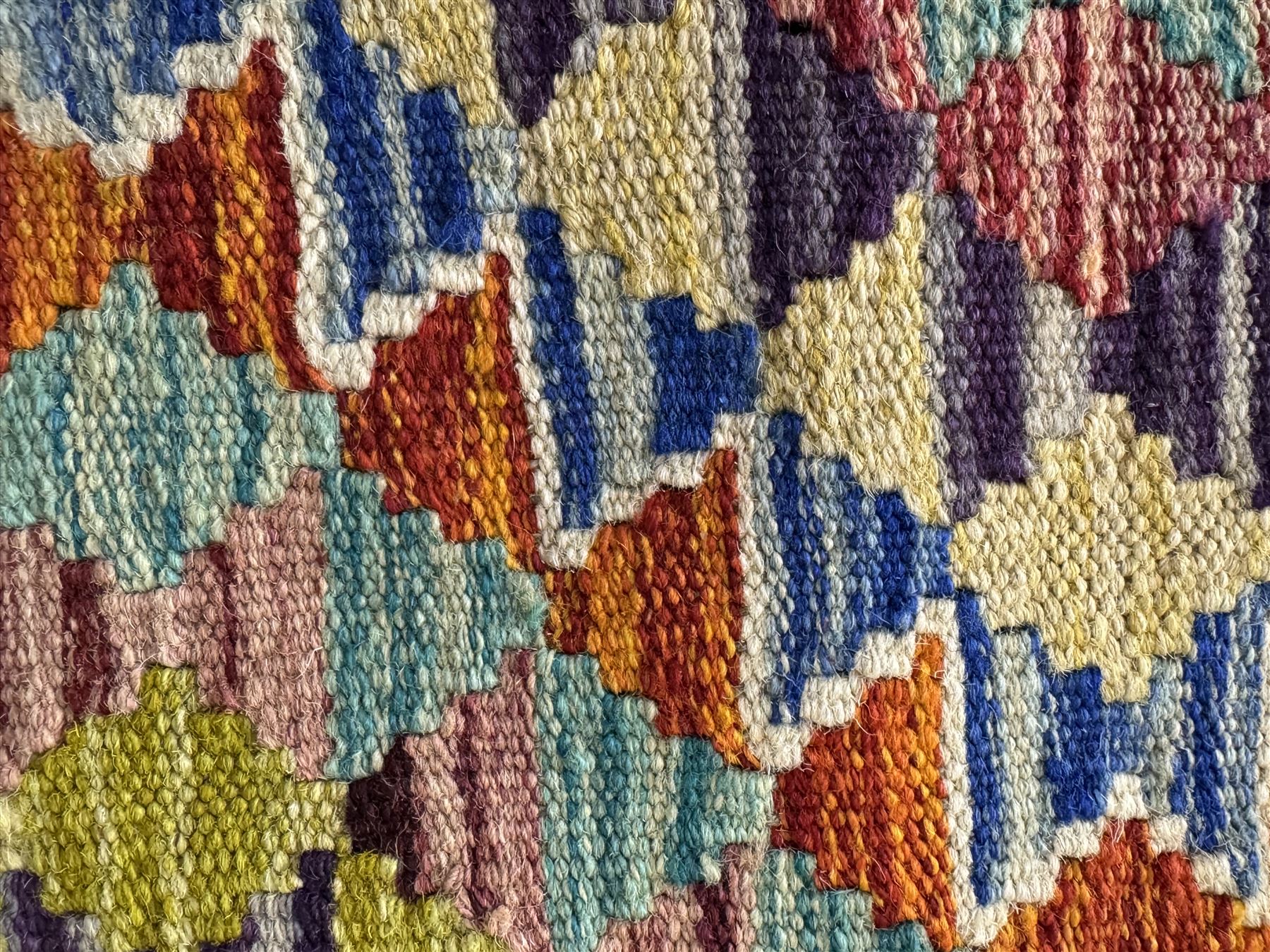 Chobi Kilim flatweave rug, dark navy ground with a vibrant multicoloured diamond lattice, framed by stylised border motifs, braided corner tassels
