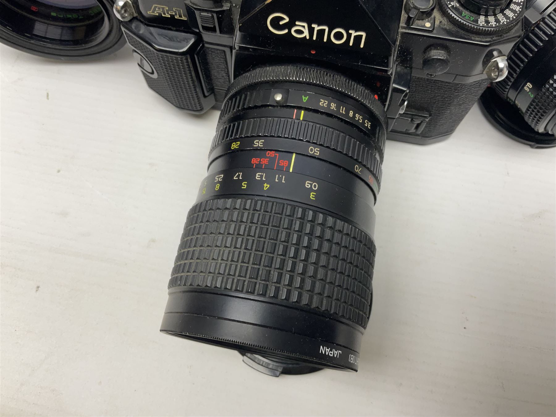 Canon A1 35mm camera body serial no 741264, with 'Tokina AT-X 28-85mm 1:3.5-4.5' lens serial no 821679, 'Canon FD 50mm 1:1.8mm' lens and other camera equipment 