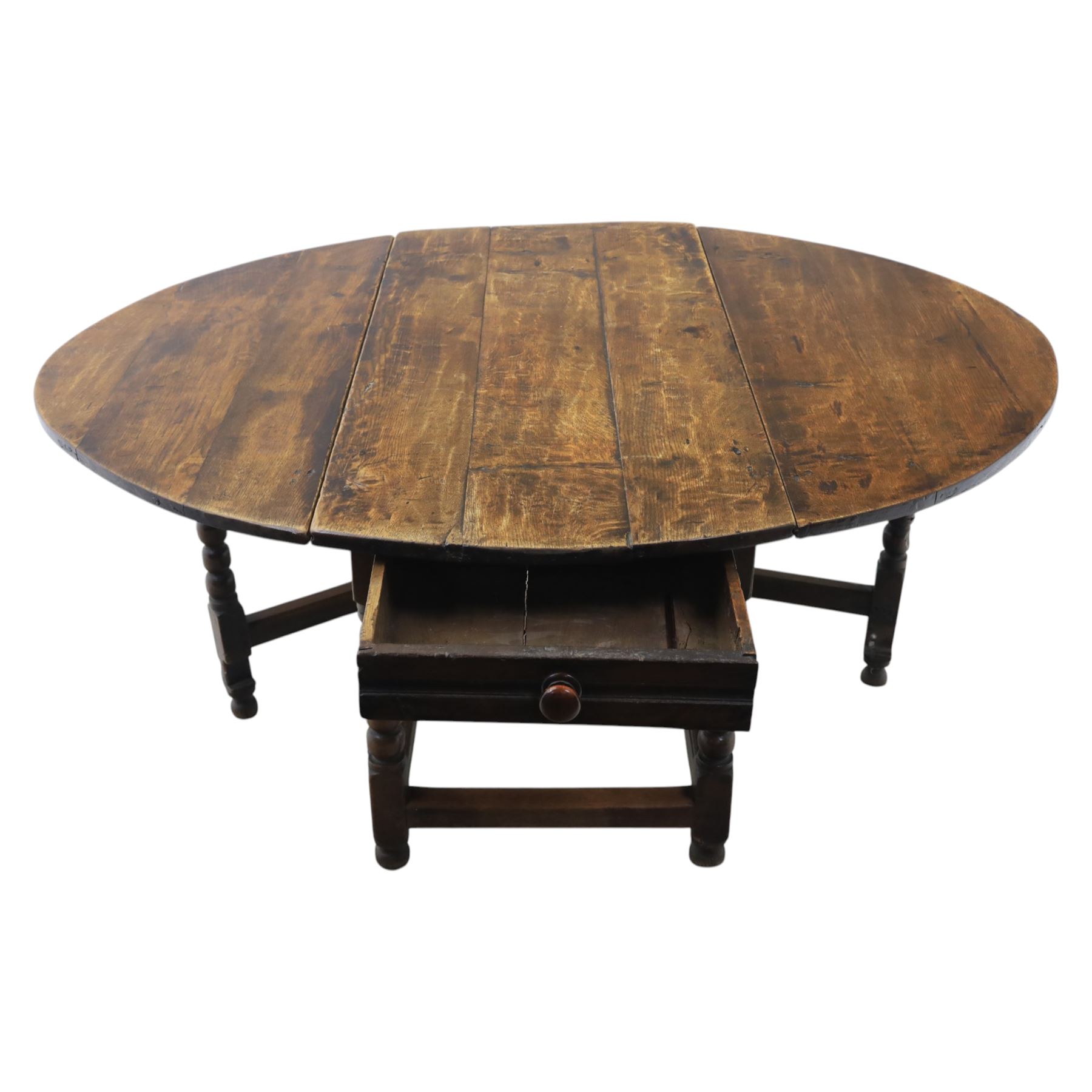 18th century country oak oval dining table, plank top with two drop leaves and gate-leg action, single drawer, raised on bobbin turned legs