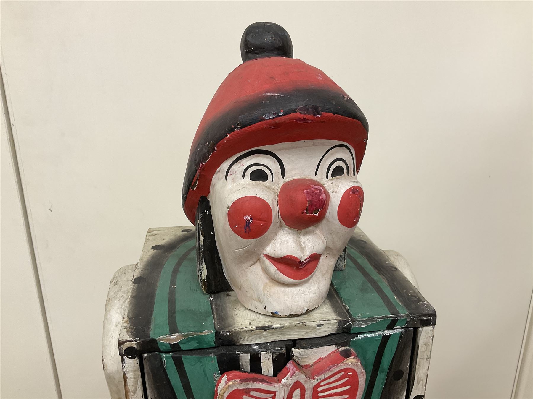 Folk art circus clown cabinet, the the two hinged doors with bow tie decoration opening to reveal fitted shelved interior, the body painted with polka dots and spades, H121cm