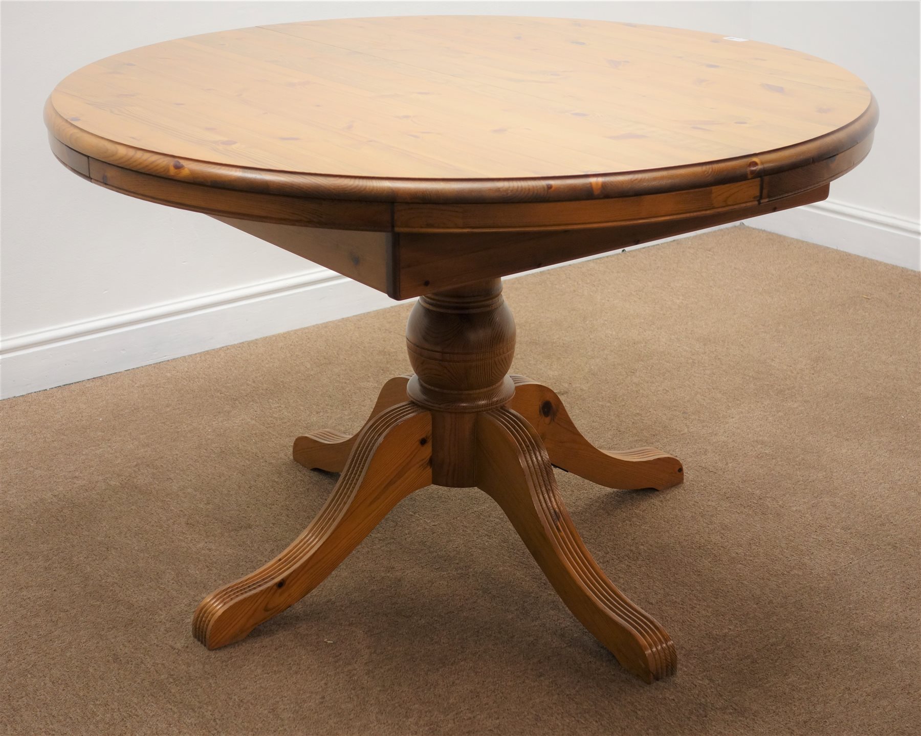 Ducal pine circular extending dining table, moulded top, single turned
