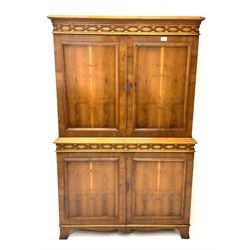 Mid century yew wood cocktail cabinet, projecting cornice, two doors enclosing mirrored interior with single shelf and slide above two cupboards, shaped platform base 