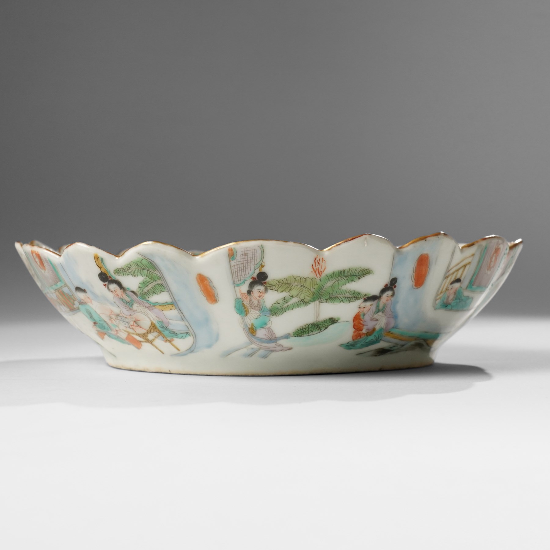 Chinese Kangxi period famille verte bowl, painted with seven figures in a pavilion interior, in Cantonese style border with foliate rim, the exterior painted with similar scenes, D24cm