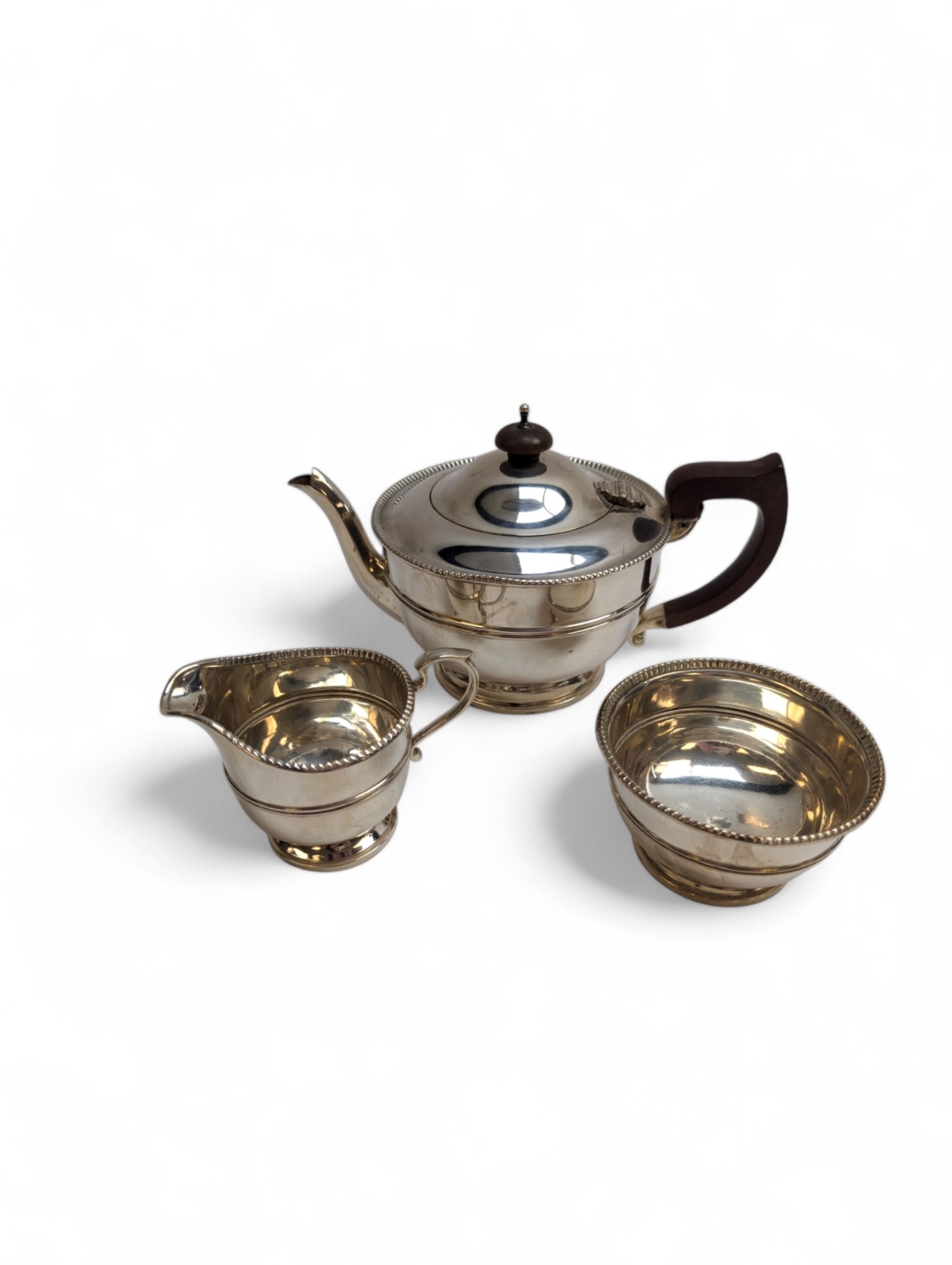1930s silver three piece tea service, comprising teapot, milk jug and sugar bowl, each of circular form with oblique gadrooned rim, the teapot with Bakelite handle and finial, hallmarked Mappin & Webb Ltd, Birmingham 1931, teapot H14.5cm