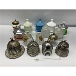 Collection of glass beehive honey pots, to include a blue slag example, milk glass, pink, green, etc together with four white metal examples (16) 