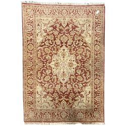 Persian design beige and crimson ground rug, the field decorated with interlacing scrolled foliage, repeating border within guard stripes 