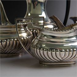 Edwardian silver four piece tea service, comprising coffee pot, teapot, twin handled open sucrier and milk jug, all of oval bellied form, part fluted and with oblique gadrooned rim, with Bakelite type handles and finials to teapot and coffee pot, hallmarked Fordham & Faulkner, Sheffield 1913