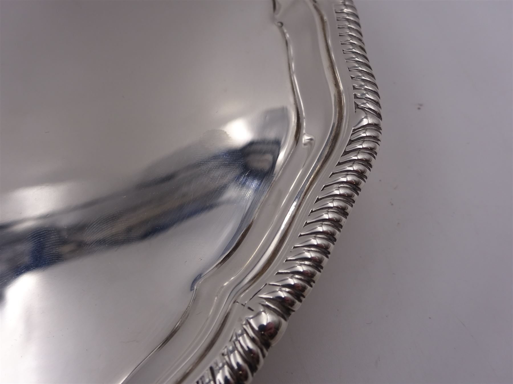 Early 20th century silver waiter, of hexagonal form, with oblique gadrooned rim, upon four ball and claw feet, hallmarked Goldsmiths & Silversmiths Co Ltd, London 1919, D21cm