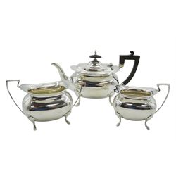 Early 20th century silver bachelors three piece tea set, comprising teapot, twin handled sucrier and milk jug, each of oval bellied form upon four pad feet, the teapot with scroll capped ebonised wooden handle and finial, hallmarked Walker & Hall, Sheffield 1912, approximate total gross weight 25.07 ozt (780 grams)