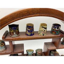 Collection of cloisonné thimbles to include bird head examples, together with a Chinese wall display case