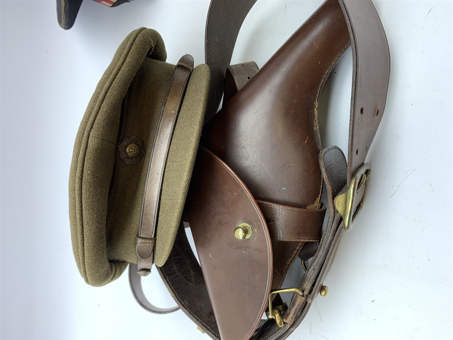 Scots Guards - two officer's peaked caps with chin strap and side buttons, one with badge, and blue dress peaked cap marked HEB for Harold Ellett-Brown; two Artist Rifles and one West Yorkshire cap badges and two Scots Guards shoulder flashes; officer's brown leather Sam Brown belt with shoulder brace strap and revolver holster; officer's Orilux trench torch etc