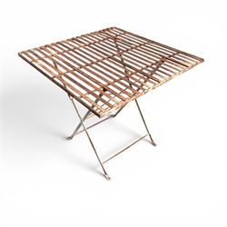 Pair of French 1920's wrought metal folding bistro café tables, the strapwork top over a folding X-frame base, in rustic white painted finish