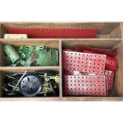 Meccano - wooden box containing a quantity of predominantly red/green playworn sections, pulley wheels, rods etc; together with a quantity of loose playworn sections, wheels etc in various colours