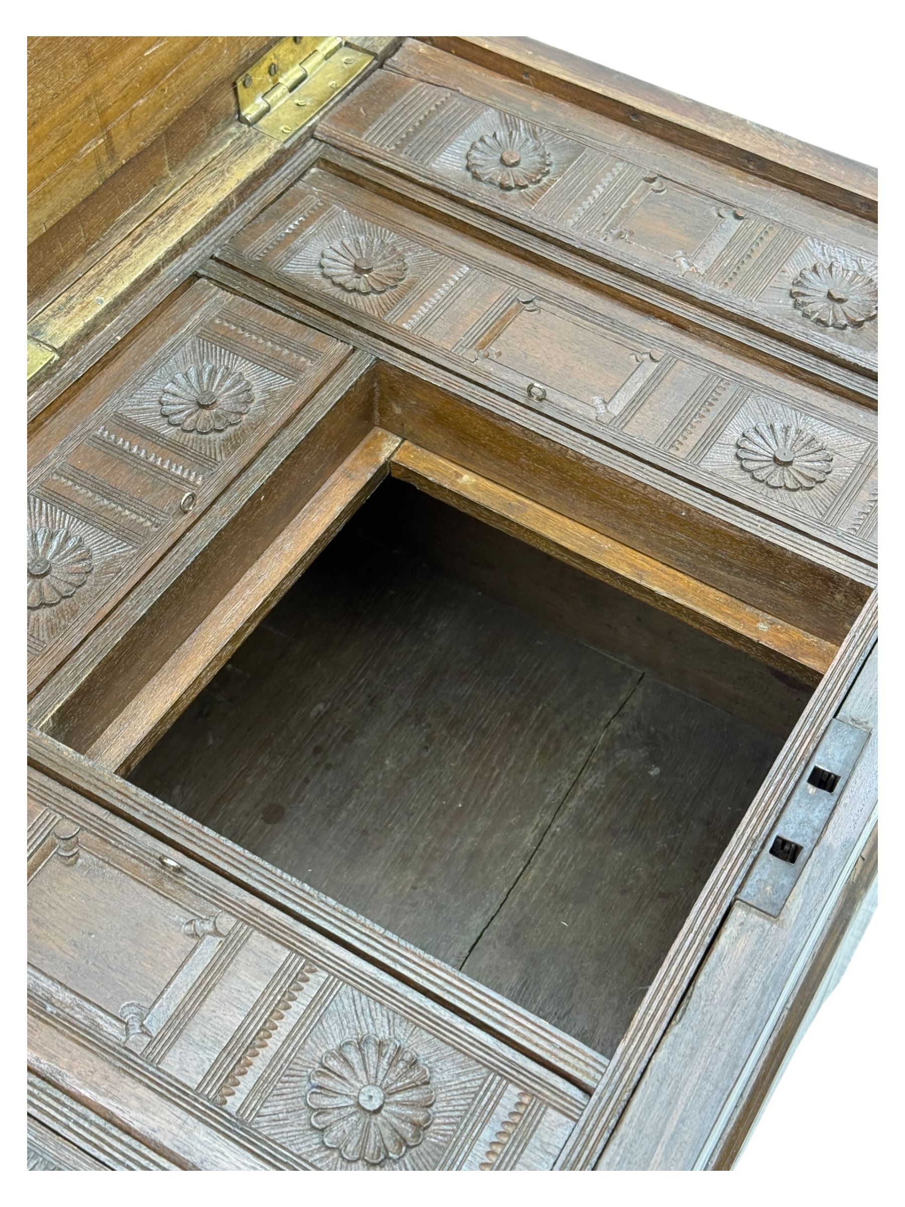 Zanzibar chest, early 20th century, of hardwood construction with brass inlaid foliate and geometric decoration to the lid, fitted interior of multiple carved compartments, with brass strapwork, side handles, and shaped bracket feet