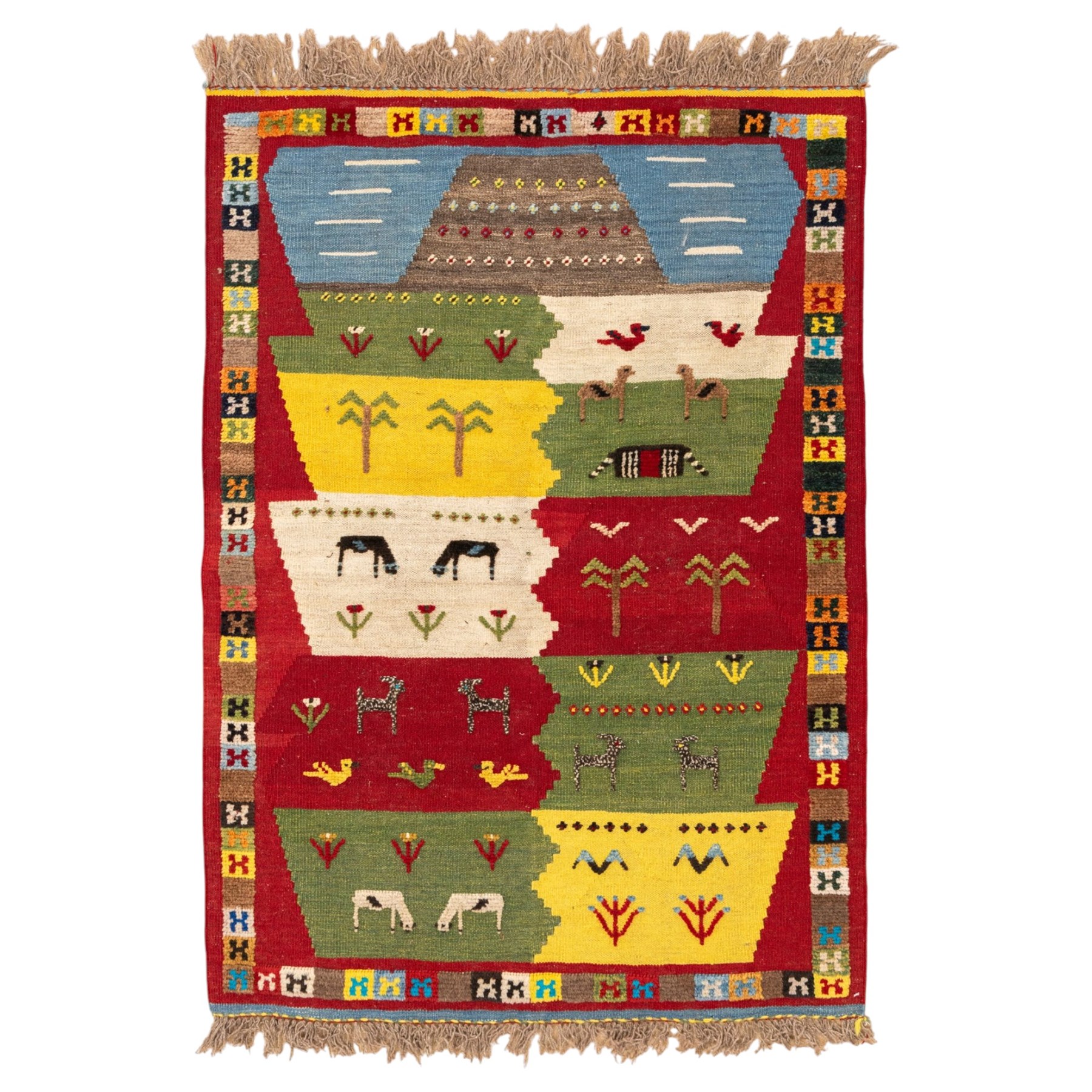 South West Persian Qashqai kilim, the field arranged with stepped polychrome panels depicting stylised camels, goats, cattle and birds, interspersed with trees and flowering stems, enclosed by a red border with multicoloured geometric devices