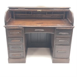  Early 20th century oak tambour roll top desk, two slides, eight drawers, plinth base, W123cm, H101cm, D71cm  
