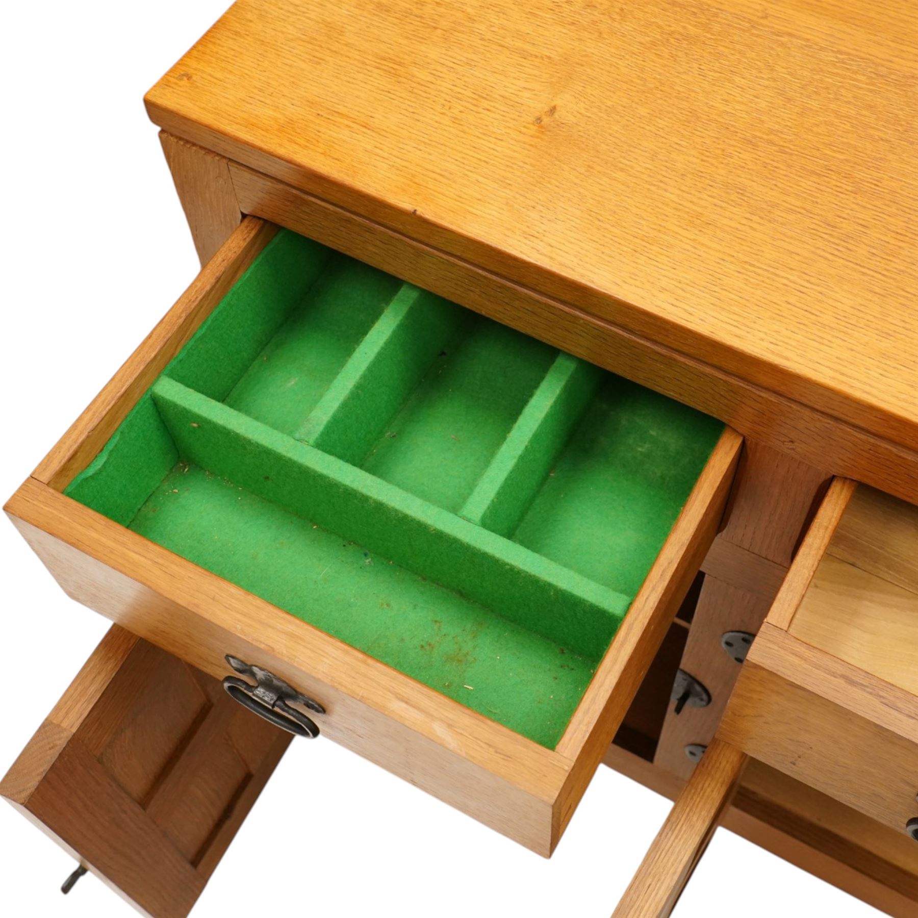 Lizardman - oak 5' sideboard, rectangular top over three panelled frieze drawers, fitted with two double panelled cupboards with wrought iron handles and locks, raised on tapered octagonal feet, with carved lizard signature, by Derek Slater of Crayke