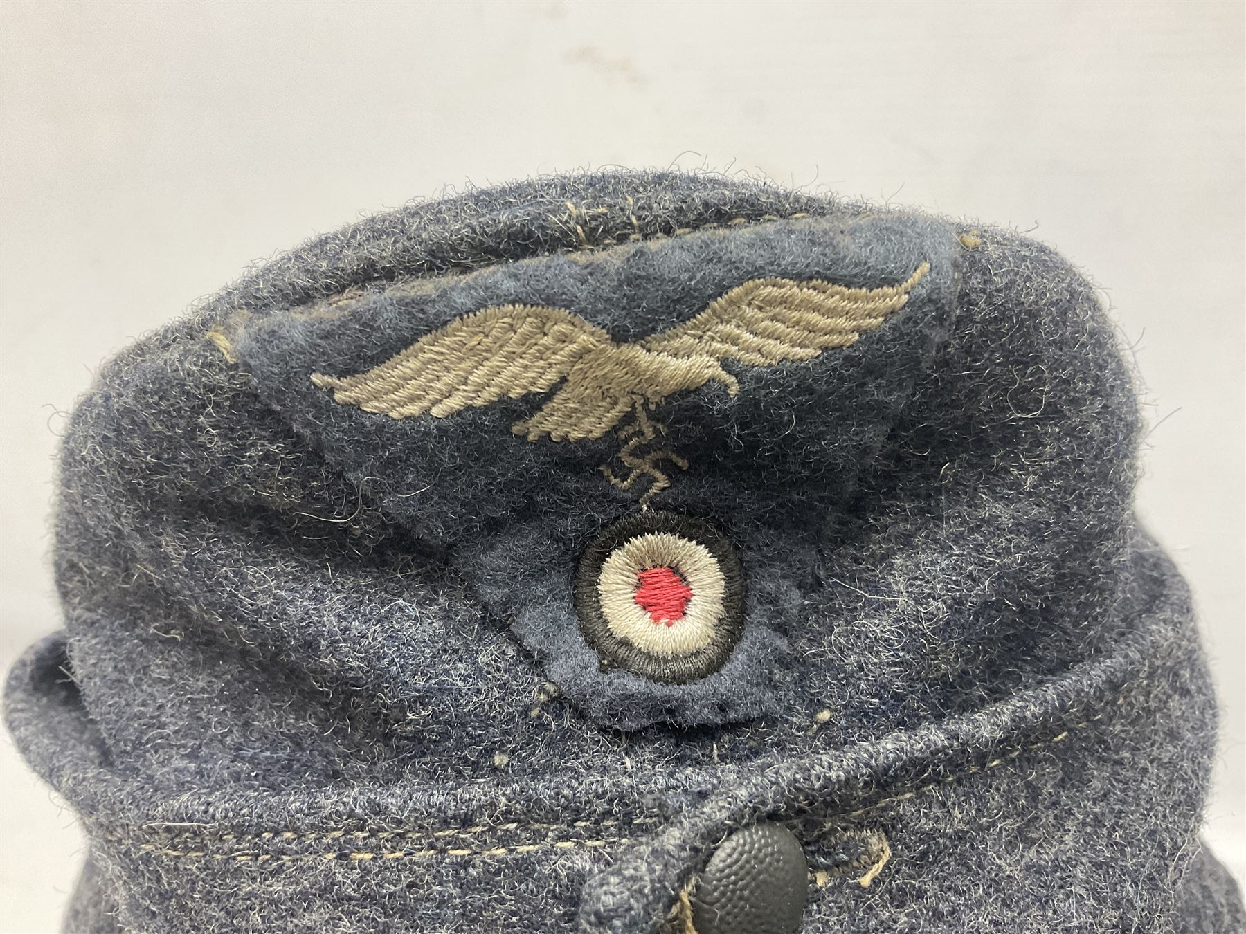 WW2 German Luftwaffe M43 field cap with triangular cloth eagle and roundel badge; marked '1944 ?/0501/0015 57'