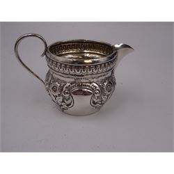 Group of silver, comprising pair of Edwardian silver open salts, of circular form, with repousse floral and C scroll decoration, and pair of matching salt spoons, hallmarked Joseph Gloster, Birmingham 1907, in tooled leather velvet and silk lined fitted case, together with a Victorian silver cream jug, of helmet form, with repousse floral decoration, hallmarked S Blanckensee & Son Ltd, Birmingham 1897, a mid 20th century silver bon bon dish, of circular form, with pierced sides, upon stepped foot, hallmarked Birmingham 1956, maker's mark worn and indistinct, a Victorian silver pepper, hallmarked Thomas Hayes, Birmingham 1895, and a silver thimble, stamped sterling