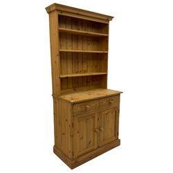 Traditional pine dresser, raised back fitted with adjustable shelves, the base with two drawers over double cupboard, plinth base
