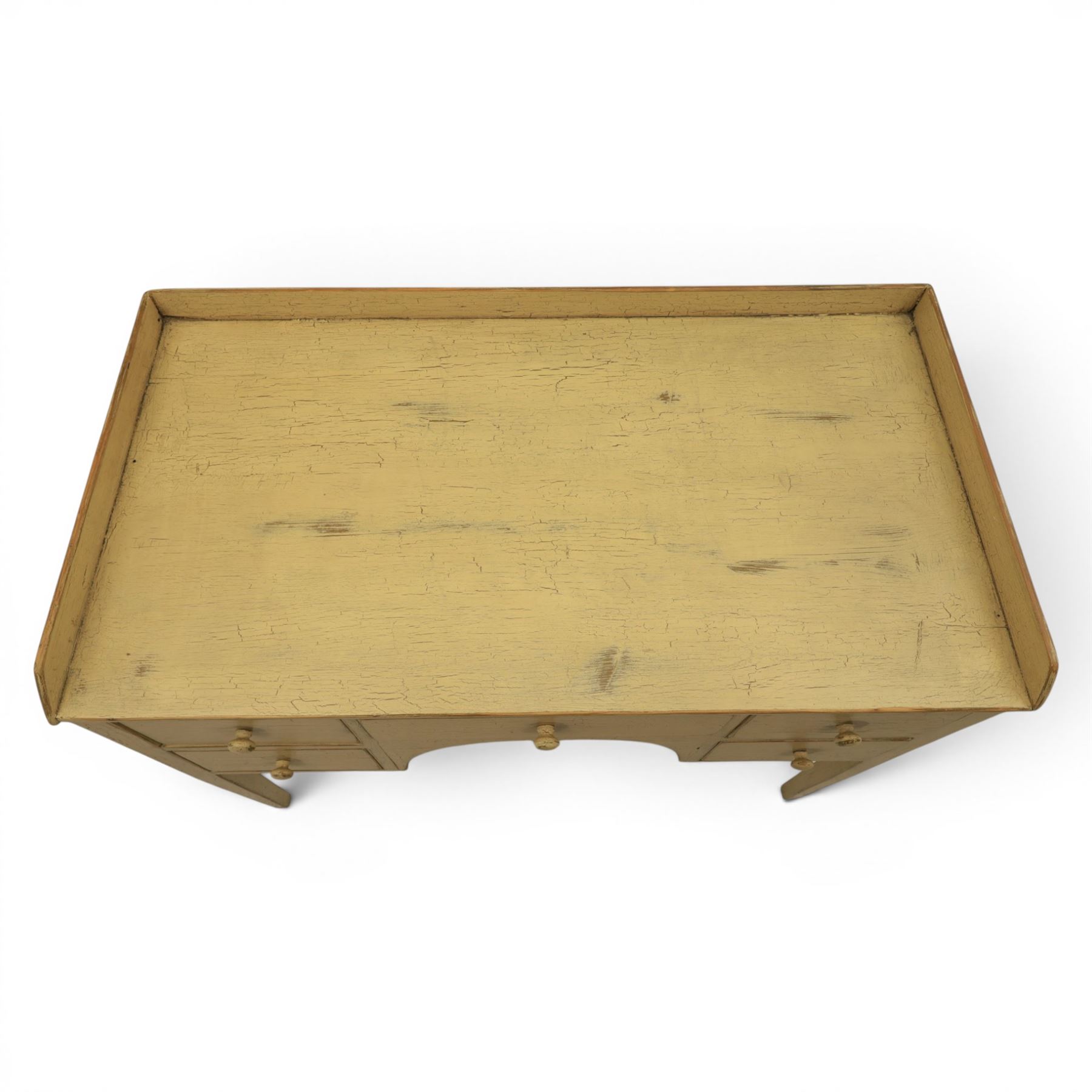 Pine country writing desk, rustic cream paint finish, galleried top over a central drawer flanked by two drawers, tapered square supports