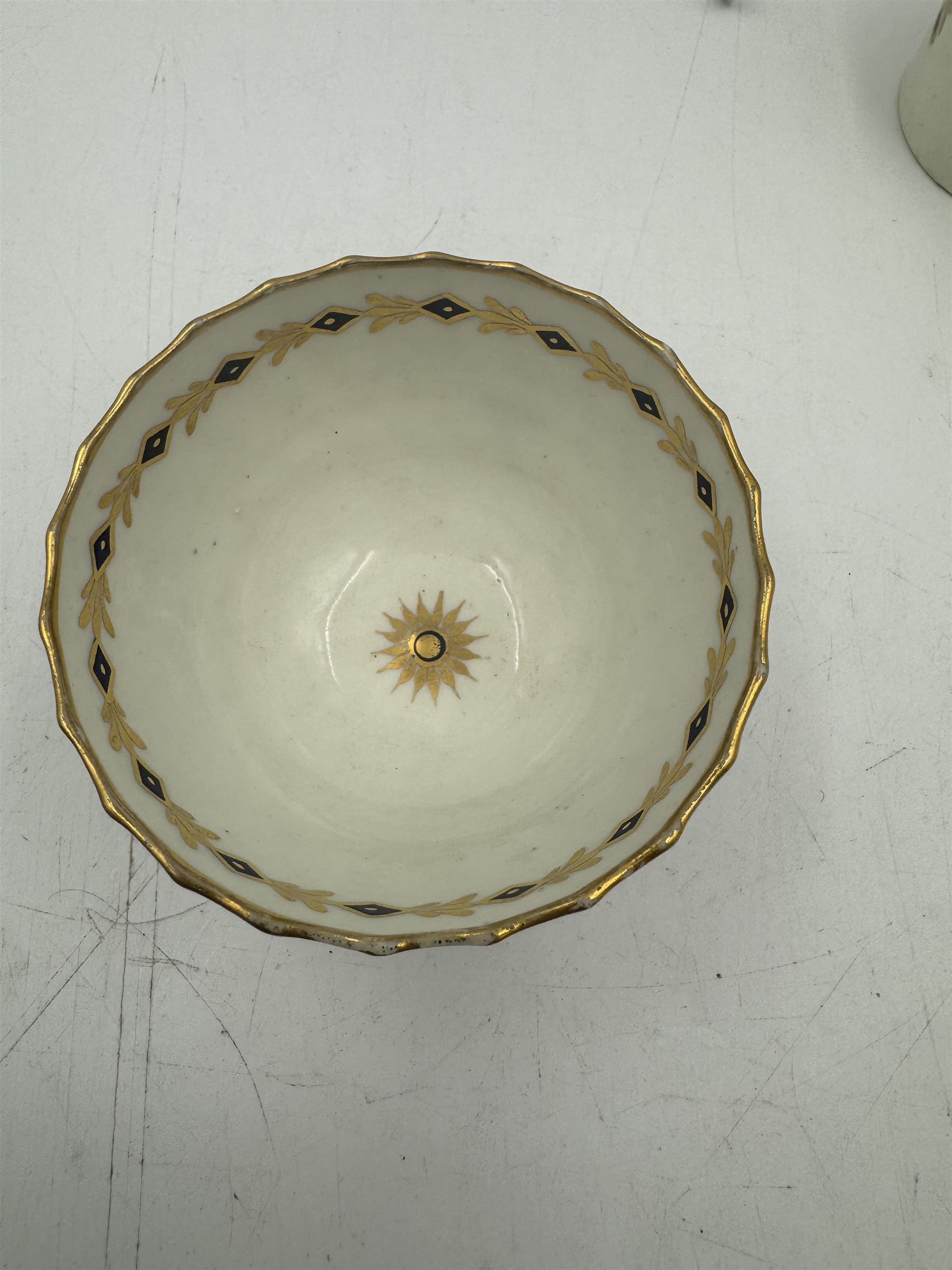 18th century Caughley blue and white sparrow jug, decorated in the Mother and Child pattern, circa 1780-1790, with underglaze C mark beneath, H9cm, together with a Worcester coffee cup, circa 1785 painted with floral sprays in underglaze blue and gilt, with crescent mark beneath, and a Caughley trio of tea cup, tea bowl and saucer, each of moulded wrythen fluted form and decorated with gilt and blue sprigs and bands, each with crescent mark beneath, (5)