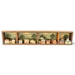 After D Chase (American 20th century): Sunday Afternoon, coloured print 19.5cm x 75.5cm; together with a diorama of an American Midwest Town with naive buildings, within a painted wooden display, houses signed named and dated 1985