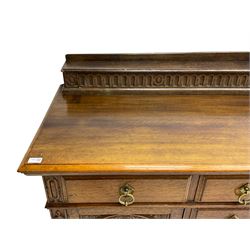 Edwardian oak sideboard, raised arcade carved back over rectangular top, fitted with four drawers, two arch carved doors doors flanking open arched centre, on turned feet