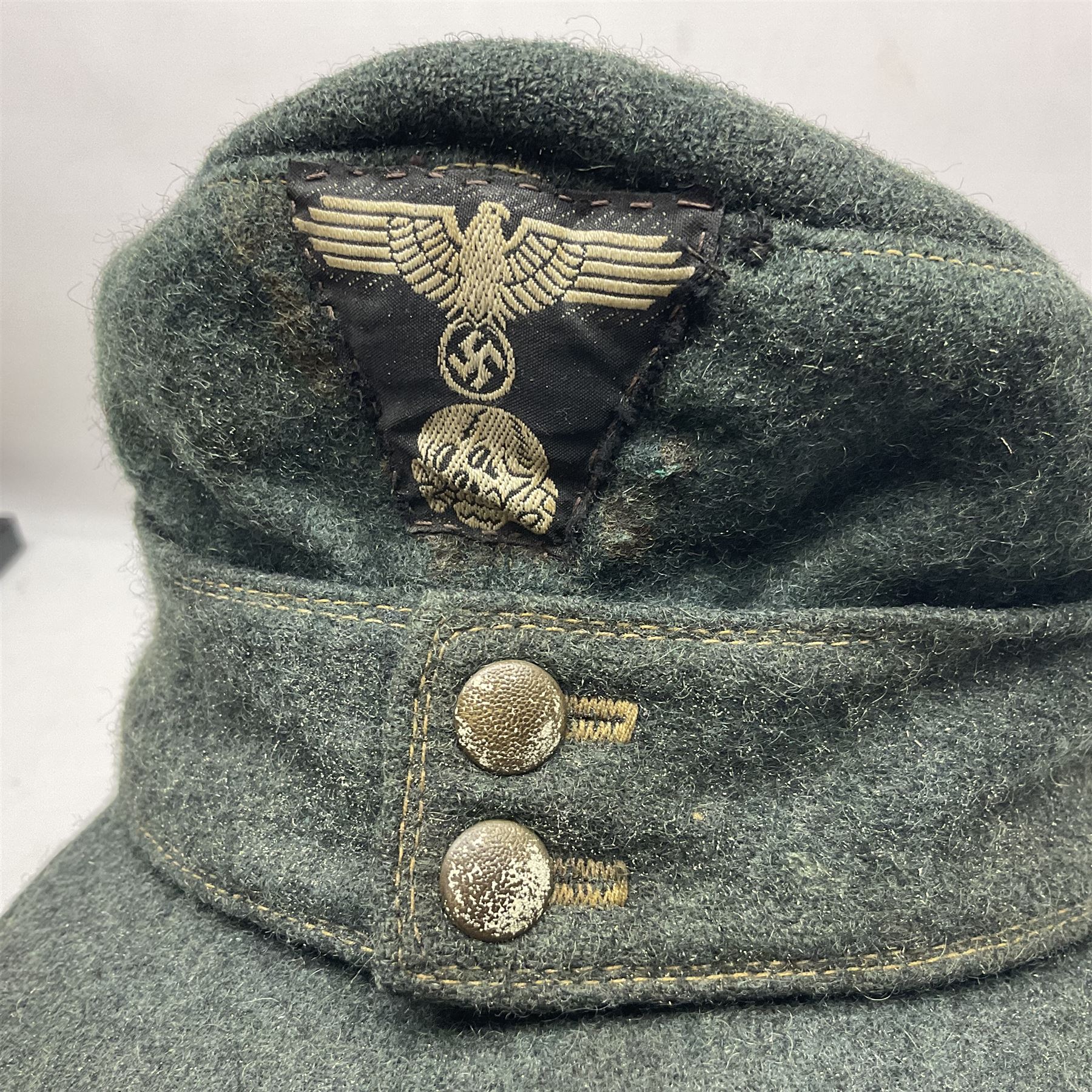 WWII German M43 field cap with 'SS' cloth badge and mountain trooper's edelweiss metal badge