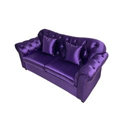 Chesterfield shaped two seat sofa, upholstered in buttoned purple fabric, with scatter cushions
