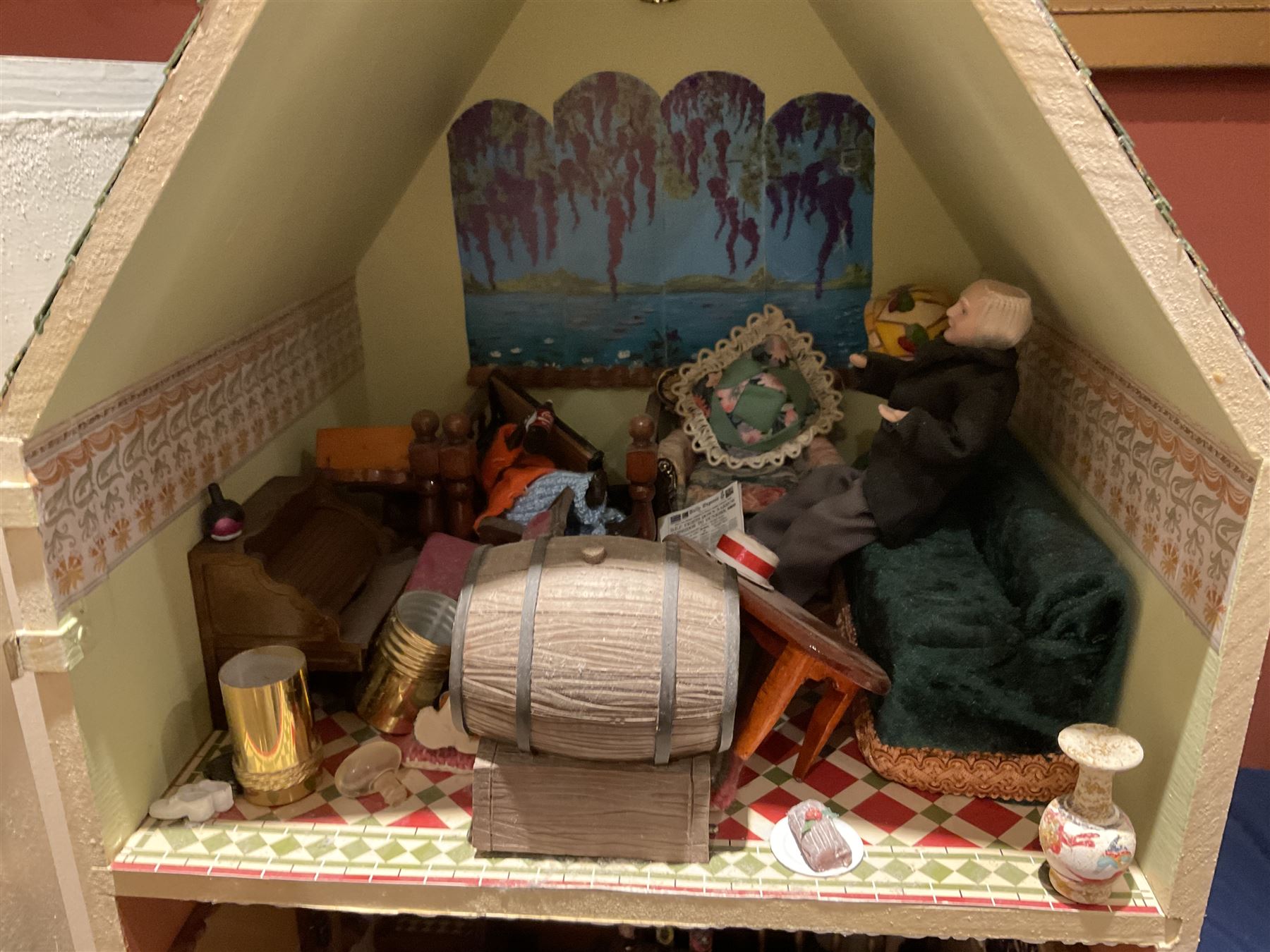 Seagull Pub - scratch-built wooden doll's house as a two-storey gable fronted public house painted in white green and maroon; the hinged front with ground floor veranda and window over opening to reveal two fully furnished rooms with dog-leg staircase and well stocked bar with bar-tender L31cm H62cm D37cm; together with Corner Shop and Dollies Pantry; a similarly painted scratch-built wooden two-storey flat-roofed doll's house as a well stocked ground floor grocery shop with stairs up to two further fully furnished rooms and more stairs giving access to a roof terrace L46cm H57cm D33cm (2)