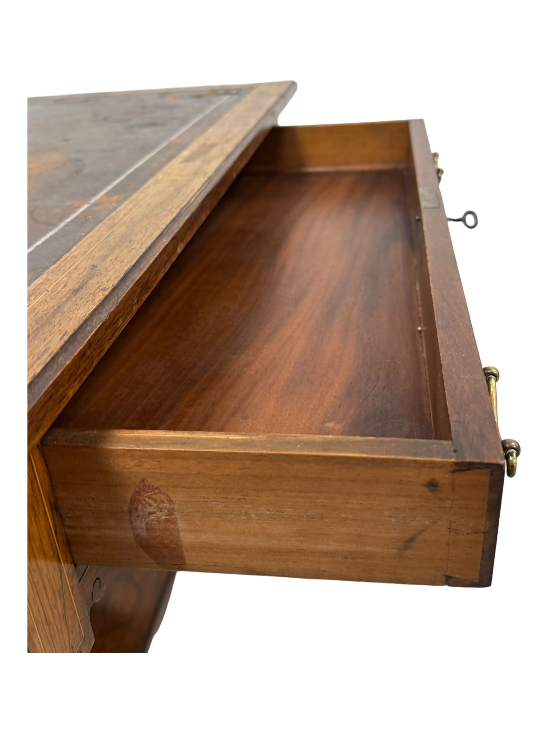 Late Victorian walnut writing table, rectangular leather-inset top surmounted by a brass gallery, fitted with a single frieze drawer, raised on turned tapering supports with lower undertier and ceramic castors