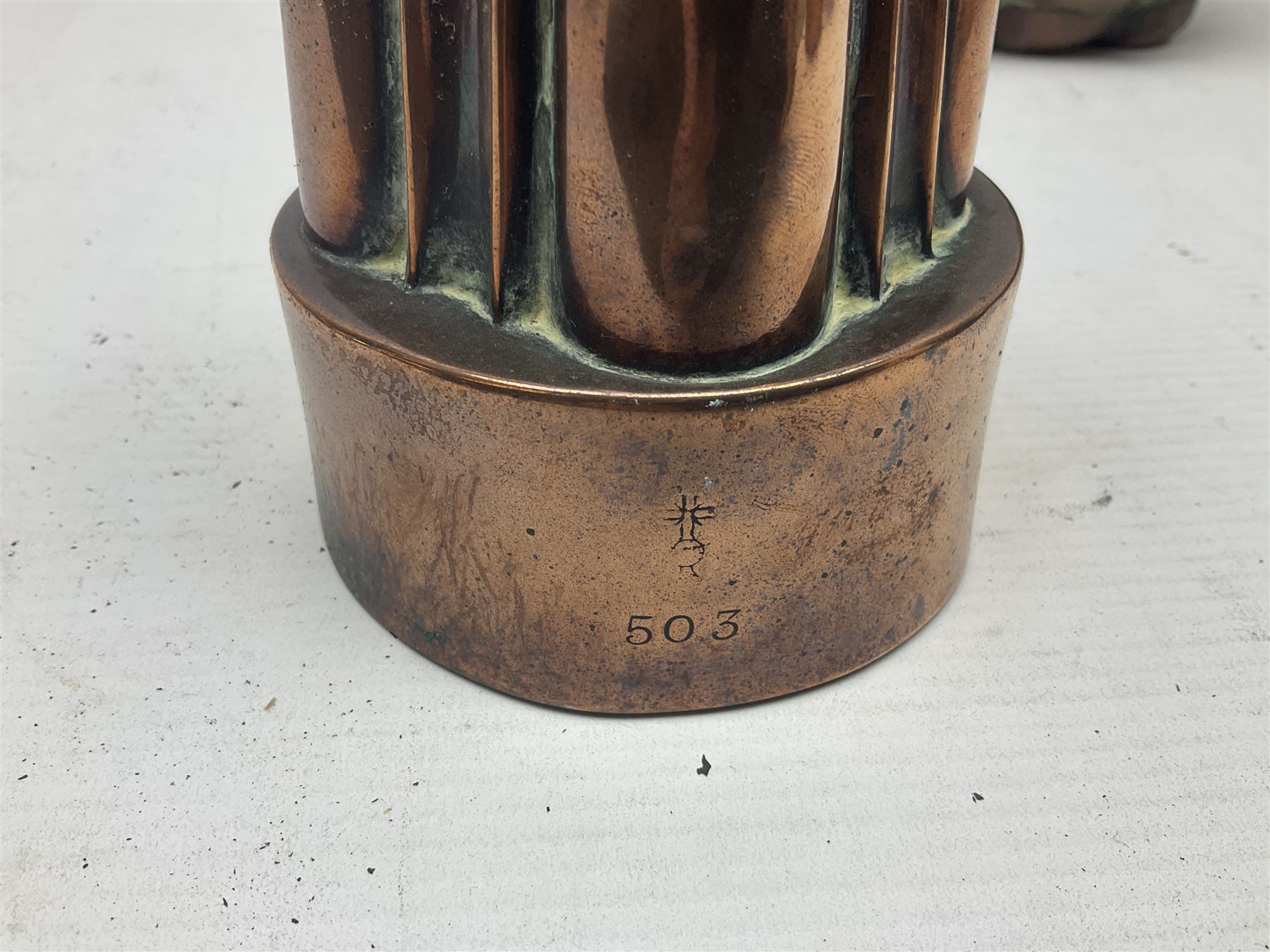 Four Victorian copper moulds, together with a graduating set of copper pans with wooden handles and finials to covers, largest pan 