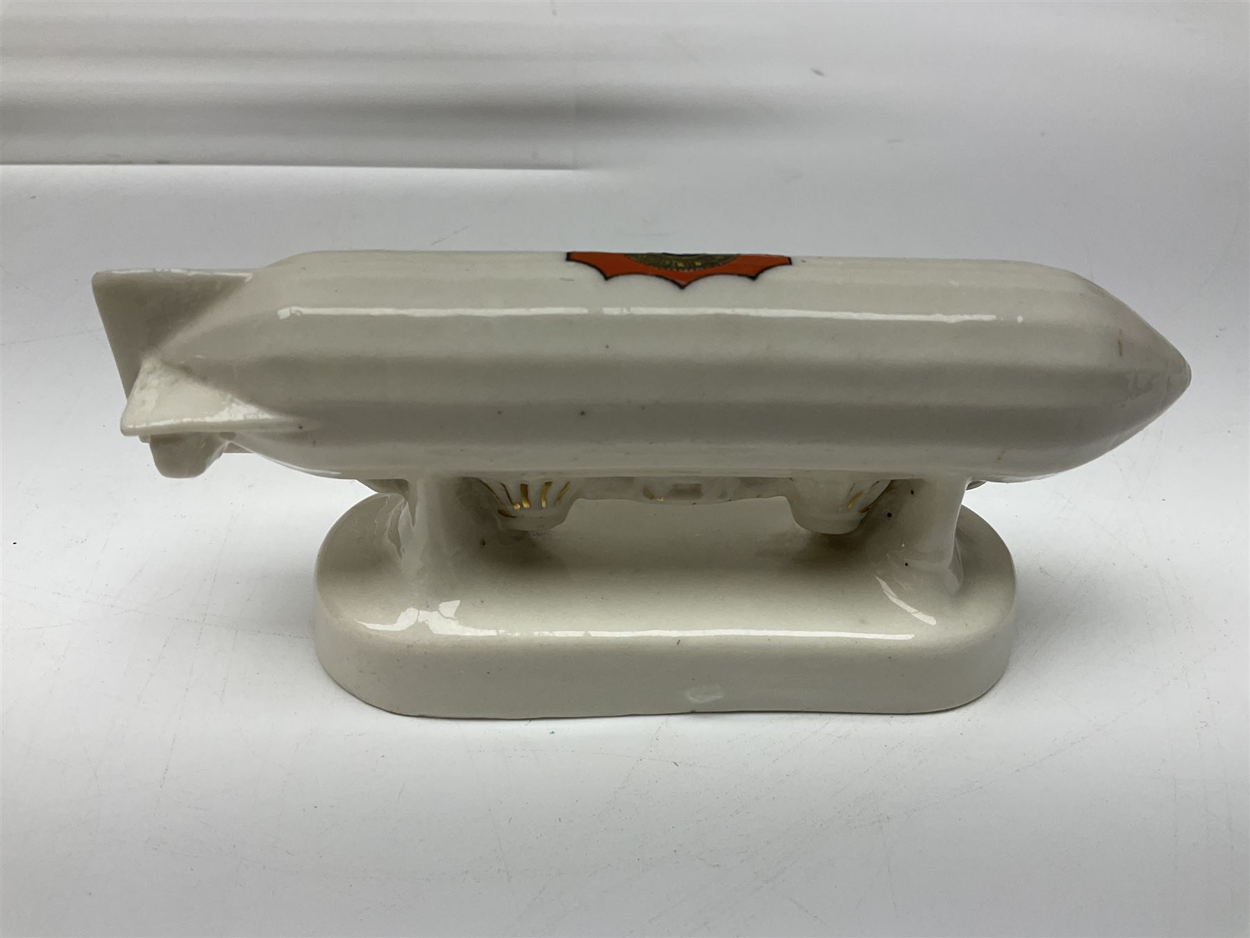 Ten WW1 crested china military models comprising submarine, four ships including Lusitania, four Zeppelins/balloons and an aircraft; various makers including Arcadian China, Swan China, Carlton China, Waterfall, Grafton China etc; various crests including Saint Neots, Great Yarmouth, Tewksbury, Swanage, Simons Town, Hull etc (10)