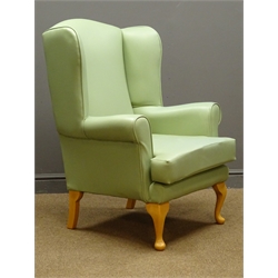  Wingback armchair upholstered in green cover  