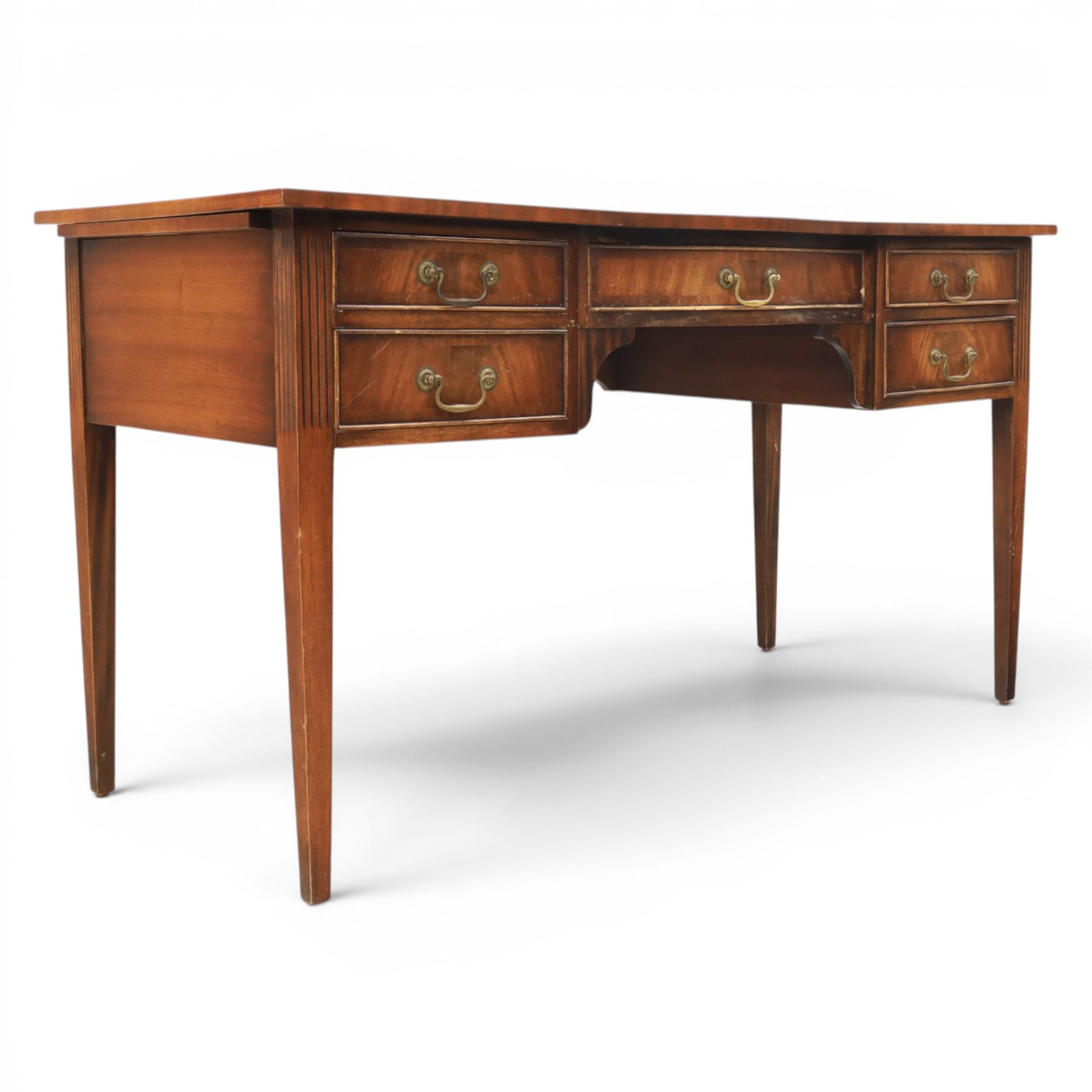 Regency style mahogany writing desk, serpentine front tooled green leather inset, slides to either side, central frieze drawer, flanked by a bank of two drawers, square tapering supports
