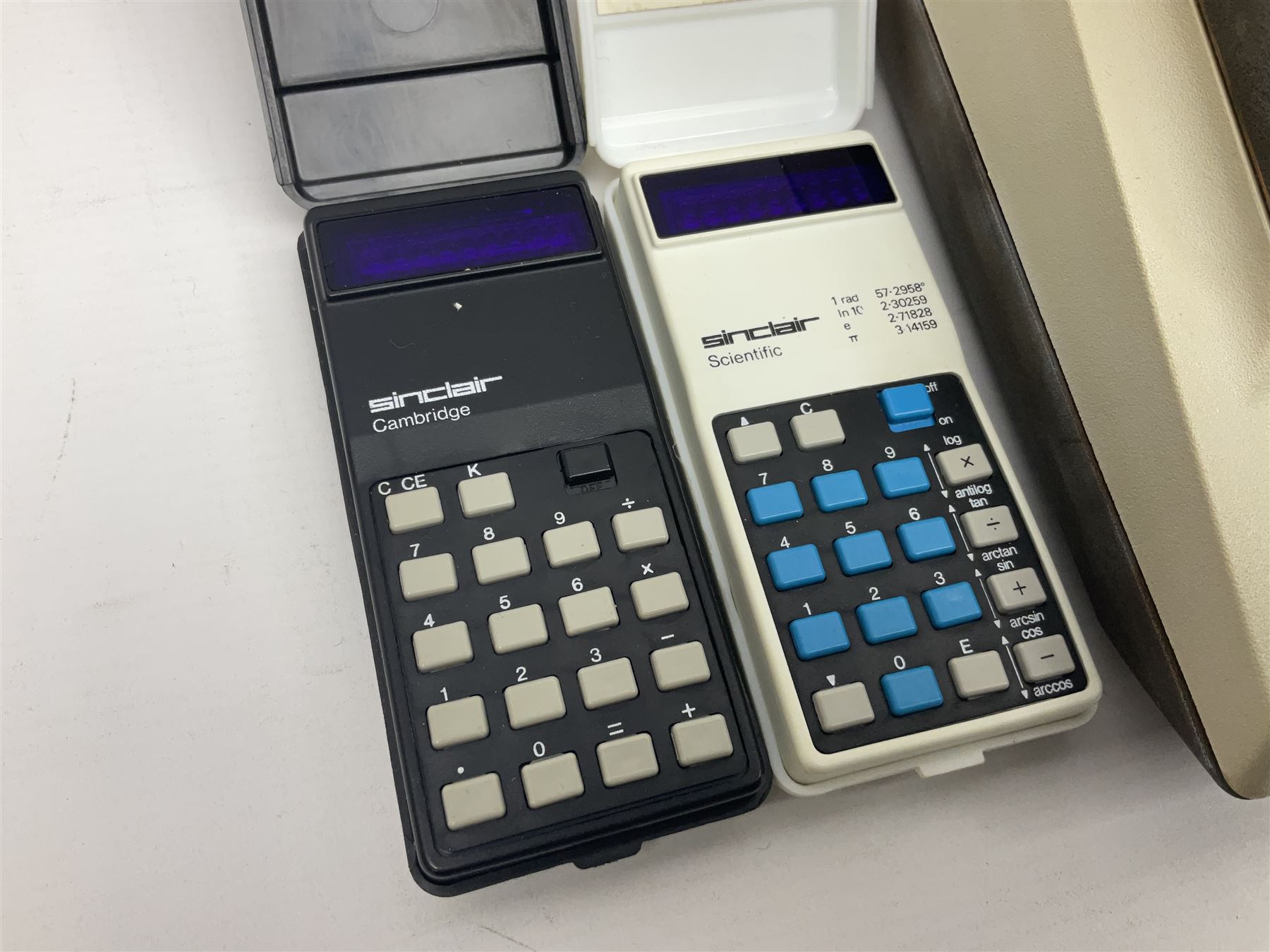 Four 1970s Sinclair electronic calculators - Cambridge in hard case with booklet; Scientific Programmable with Program Library and booklet; Scientific in hard case; and Oxford 300 in soft case with booklet; together with Texas PC-100 SR56 programmable slide-rule calculator on base station with readout, two booklets, keys and cover, serial no.9103093
