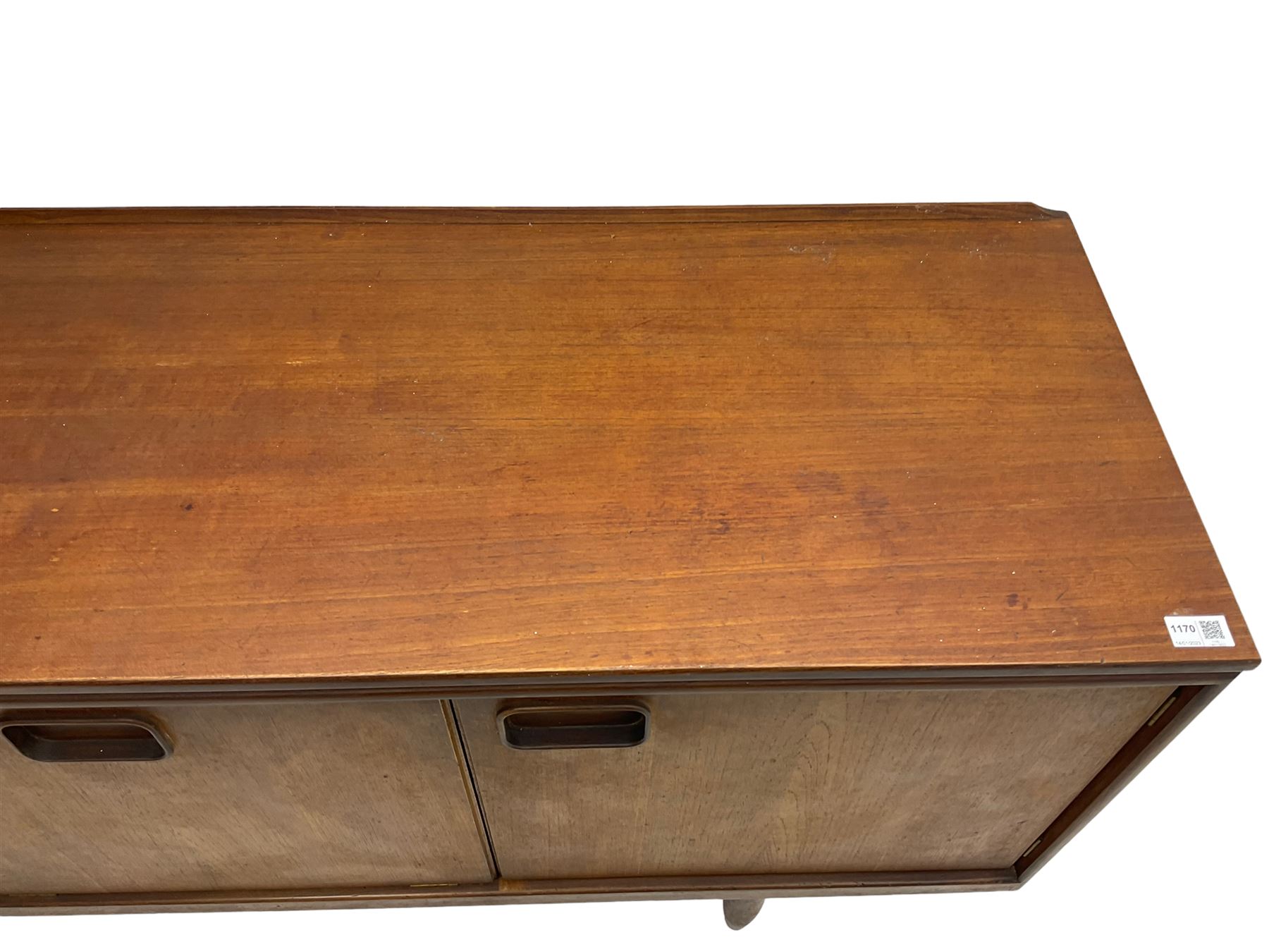 William Lawrence of Nottingham - mid-20th century teak sideboard, with low gallery back over three short drawers and a fall front, flanked by two cupboard doors, enclosing shelves, raised on tapering cylindrical supports, makers mark stamped inside drawer