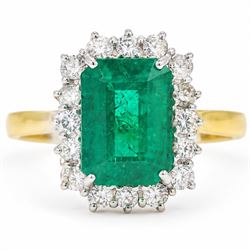 18ct gold emerald and diamond cluster ring, single octagonal cut emerald of approx 3.80 ca...